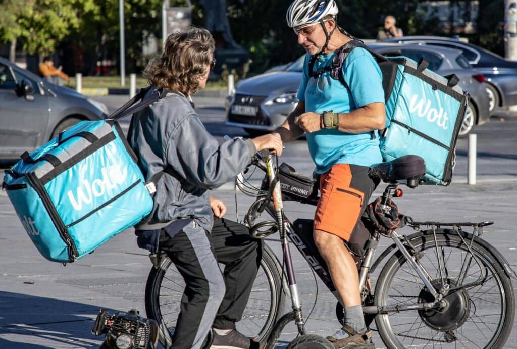 two delivery people on e-bike and e-scooter